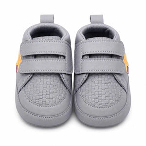 Front view of grey baby first walker shoes with double hook and loop straps and breathable textured toe design