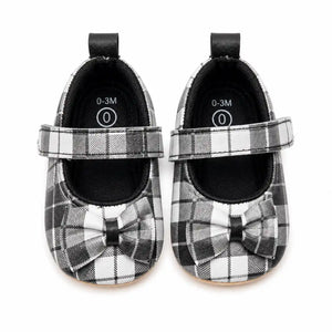 Black and white plaid baby girl Mary Jane soft sole shoes with decorative bow and hook-and-loop strap – front view