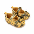 Mustard yellow and black plaid baby girl soft sole shoes with decorative bow and Velcro strap – angled view