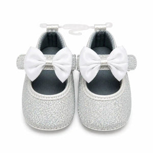 Silver white glitter baby first walker shoes with white satin bow and hook loop strap – front view