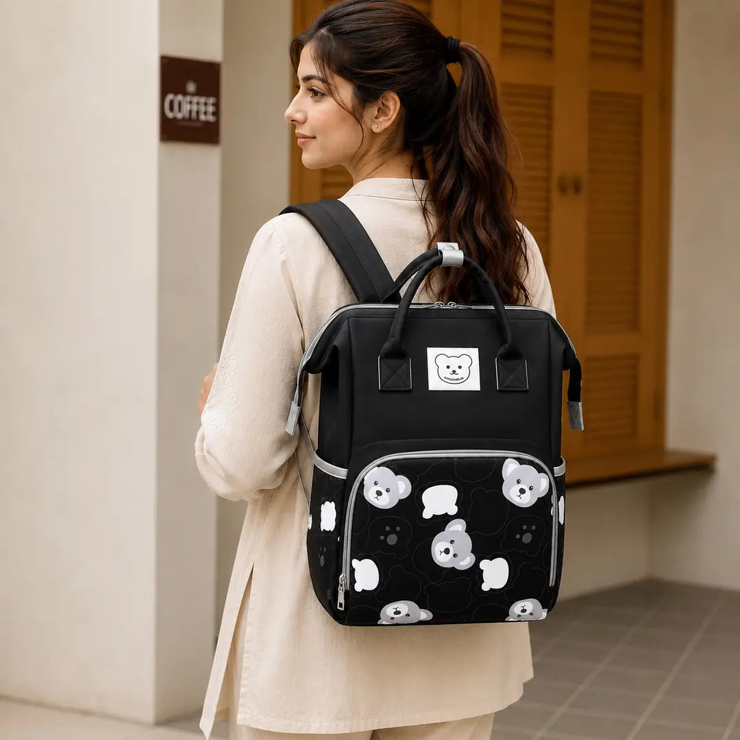 Black baby diaper bag backpack with bear print worn by mother