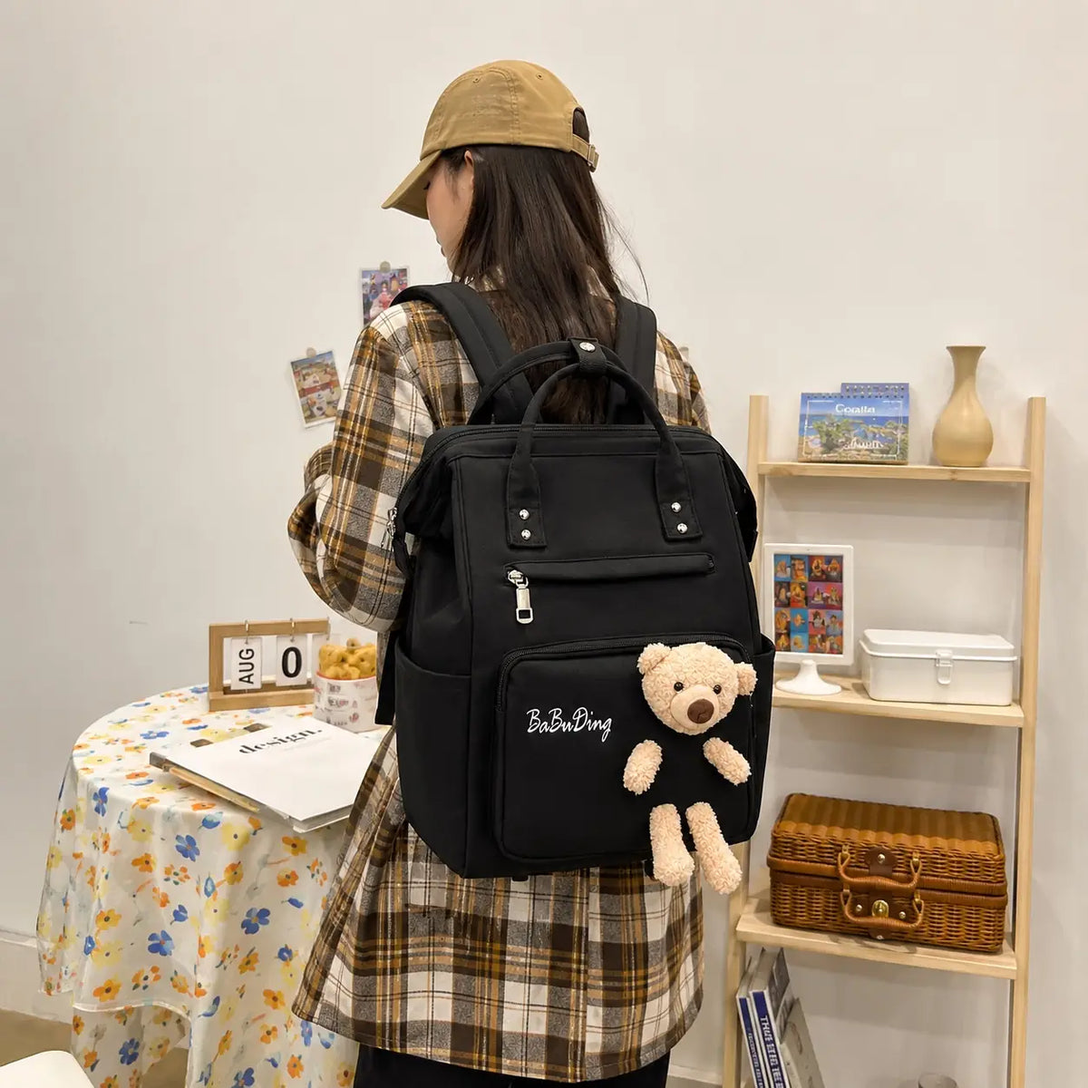 Black baby diaper bag backpack with teddy bear worn on back