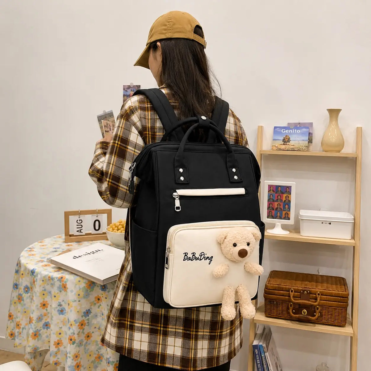 Black and white baby diaper bag backpack with teddy bear worn on back