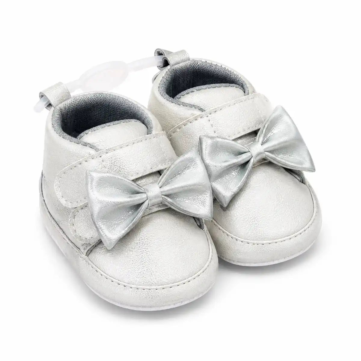 Metallic silver baby girl first walker shoes with decorative bow, hook and loop strap and soft sole – angled view