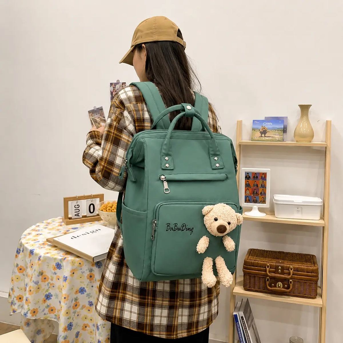 Green baby diaper bag backpack with teddy bear worn on back