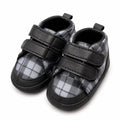 Black and grey plaid baby soft sole first walker shoes with double Velcro straps – angled view