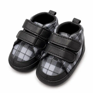 Black and grey plaid baby soft sole first walker shoes with double Velcro straps – angled view