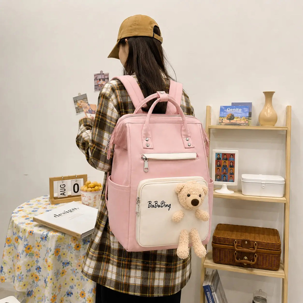 Pink and white baby diaper bag backpack with teddy bear worn on back