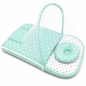 Green polka dot baby carry nest with pillow shown in portable folded view