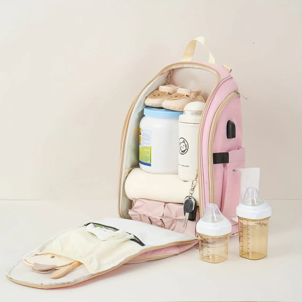 Pink baby diaper backpack open to show large capacity for baby essentials, bottles and clothing