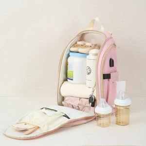 Pink baby diaper backpack open to show large capacity for baby essentials, bottles and clothing