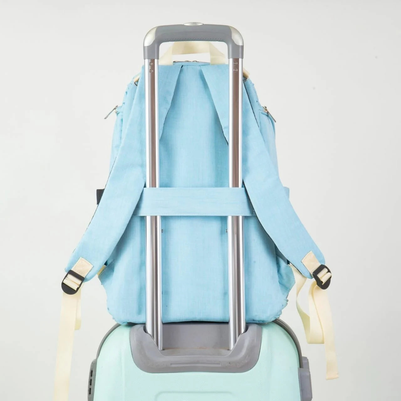 Sky blue baby diaper backpack attached to a luggage trolley with rear strap and adjustable shoulder straps