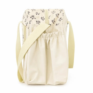 Cream baby diaper bag side view showing compact travel-friendly design