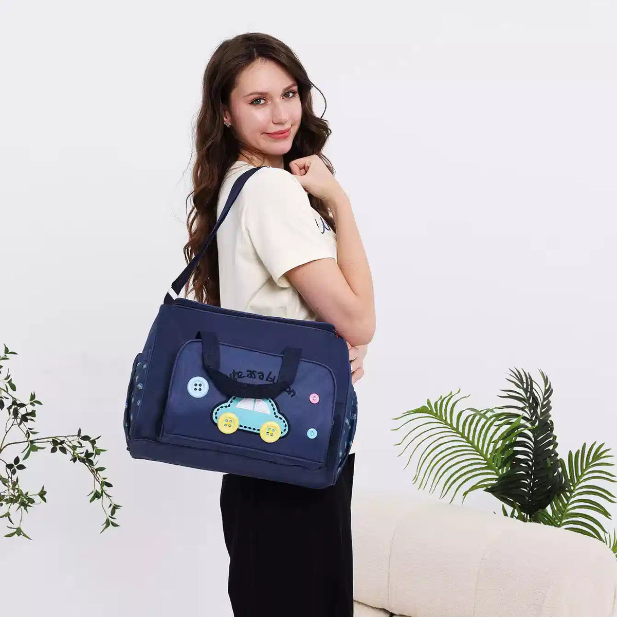 Dark blue baby travel organizer bag worn with shoulder strap