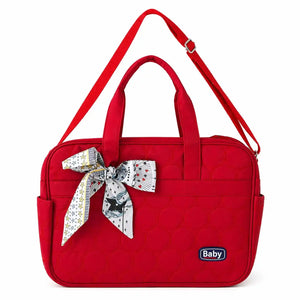 Red quilted baby diaper bag with decorative bow for travel and daily use