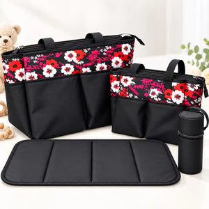4-piece black floral baby diaper bag set with red, pink and white flower print, two diaper bags, bottle holder and padded changing mat