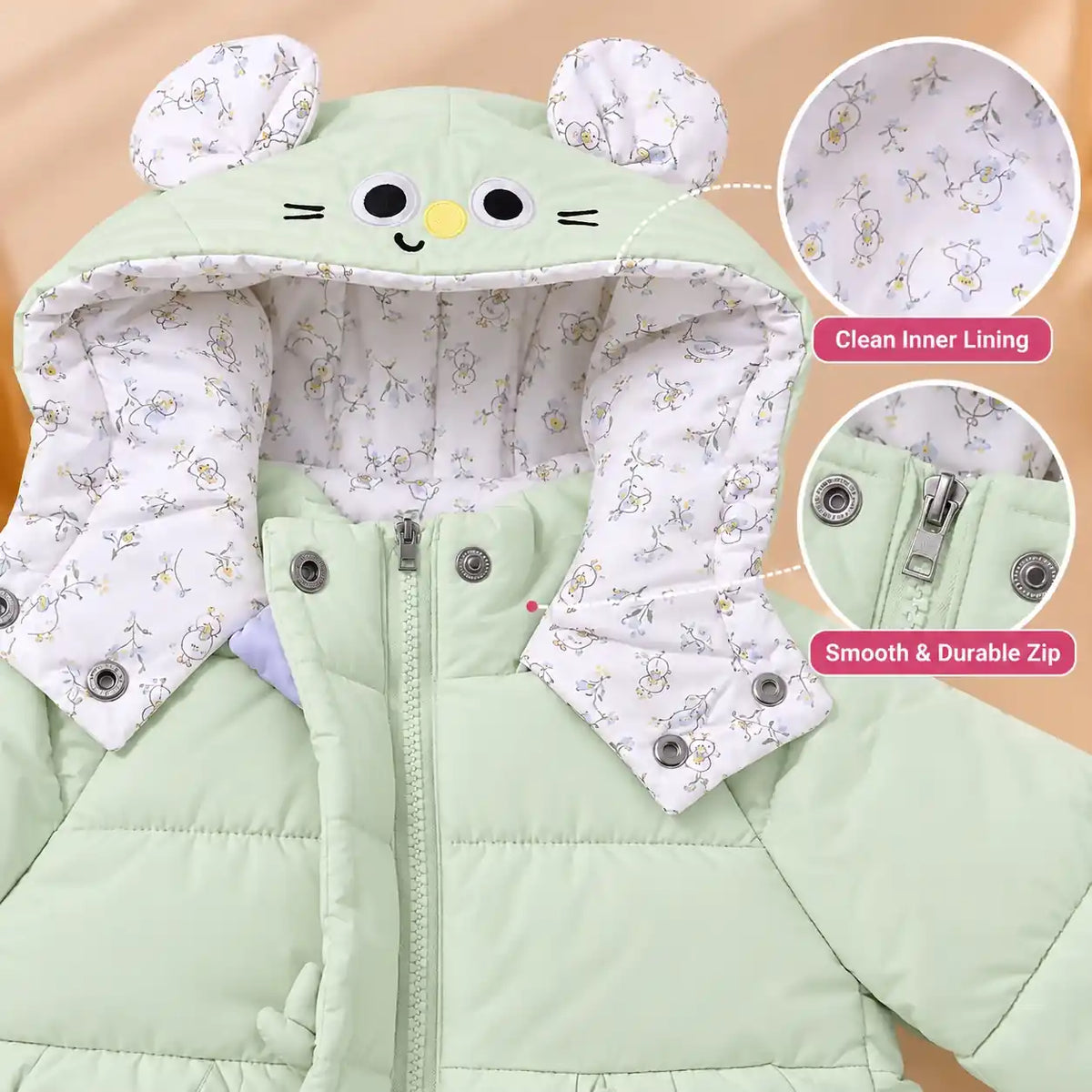 Close-up of mint green baby winter jacket showing printed inner hood lining, character ear details and front zipper