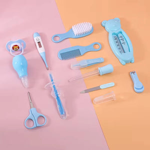 Blue baby grooming care kit accessories displayed on pink and orange background