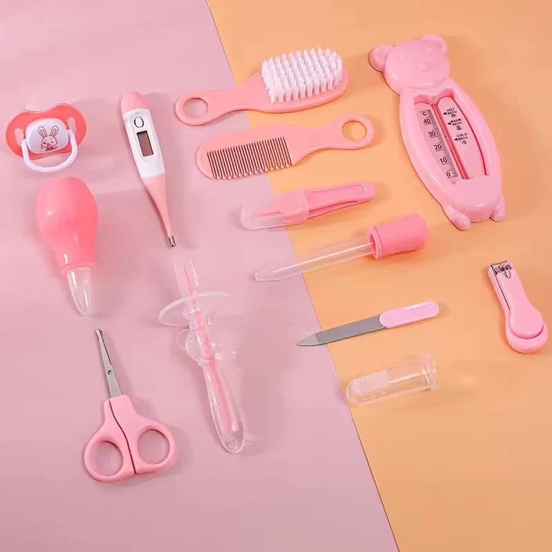 Pink baby grooming care accessories including brush, comb, thermometer, nail clipper, scissors and dropper