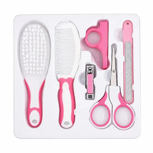Pink baby grooming care kit arranged in tray with brush, comb, nail clipper, scissors and nail file