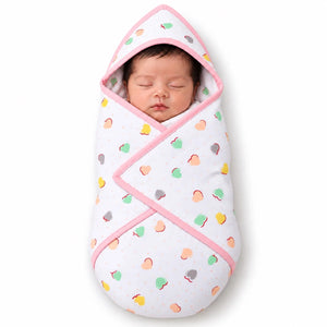 Newborn baby wrapped in pink baby hooded wrapping sheet with colorful heart pattern