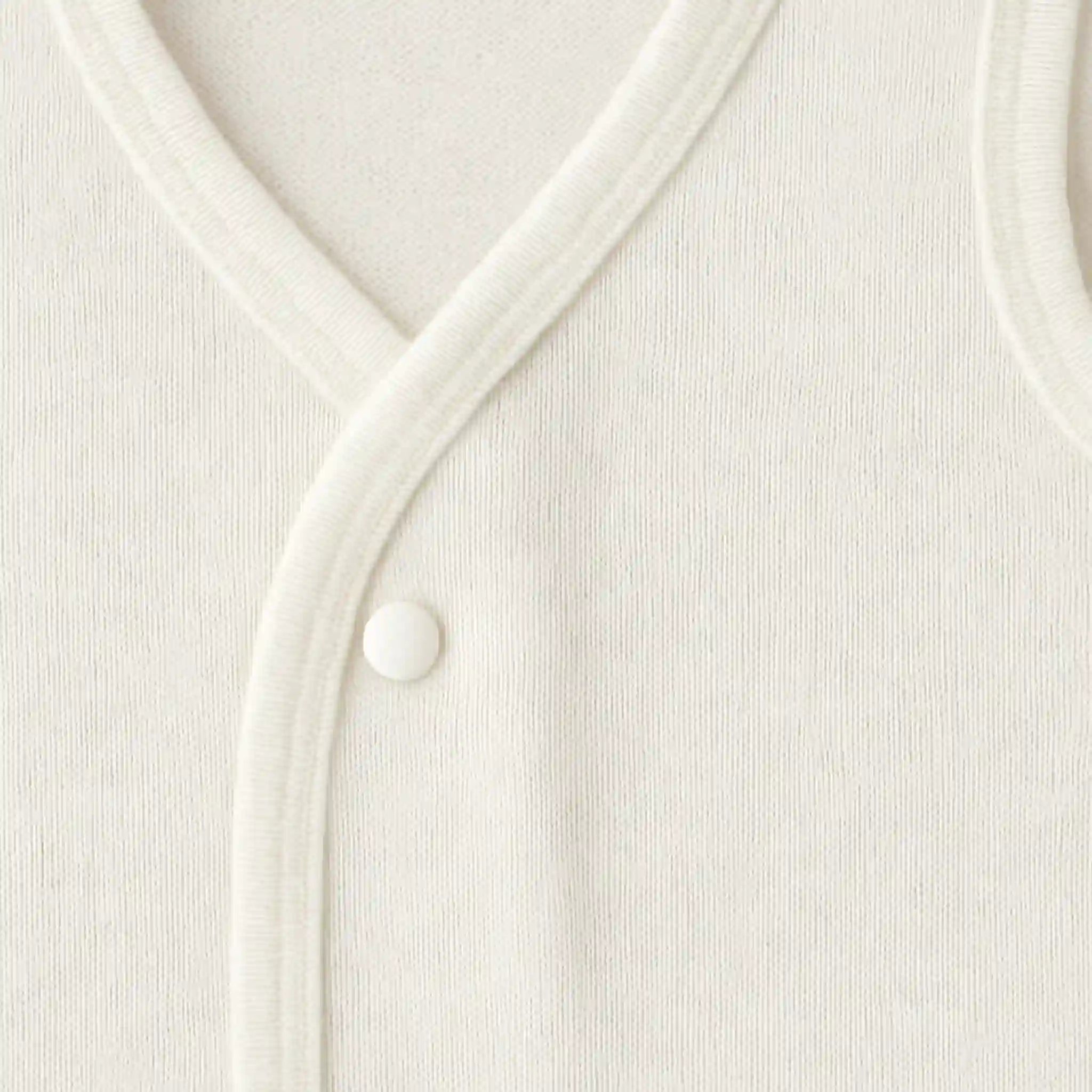 Close-up of soft white baby inner vest fabric and stitching
