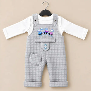 Light grey baby quilted dungaree romper with white long sleeve inner shirt, embroidered car design and front pocket