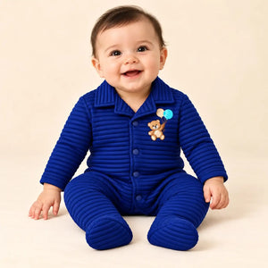 Baby wearing royal blue winter ribbed quilted footed romper with teddy bear embroidery in seated pose