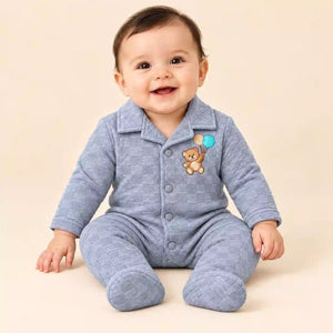 Baby wearing light grey winter quilted footed romper with teddy bear embroidery and checkered pattern in seated pose