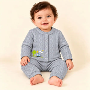 Baby wearing light grey winter shirt and pajama set with blue car, green tree and sunshine embroidery