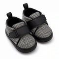 Black and grey textured baby shoes with adjustable strap angled view