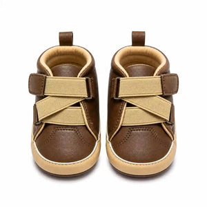 Brown baby shoes with beige cross strap design and contrast sole front view