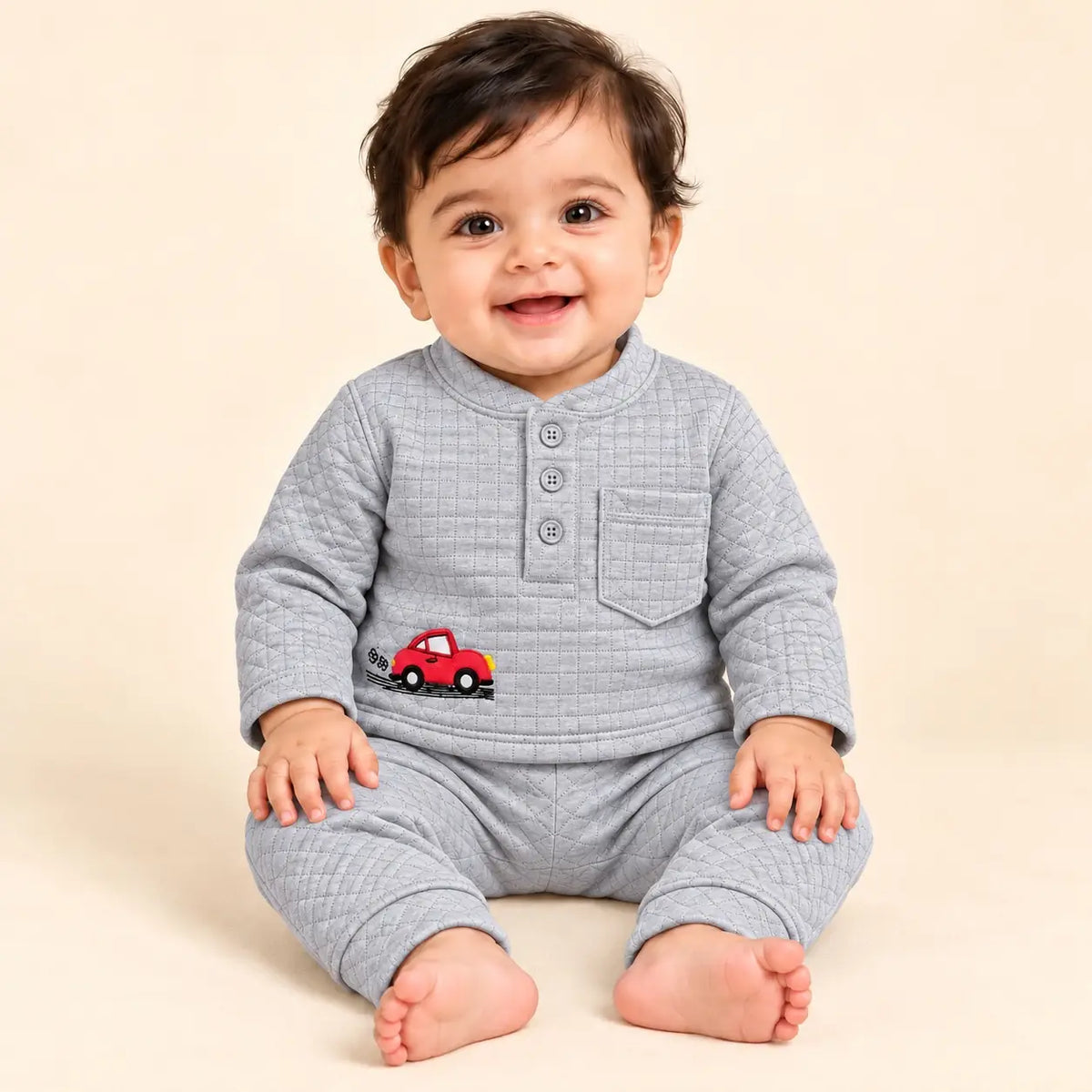 Baby wearing a light grey textured jacquard knit winter shirt and pajama set with red car embroidery