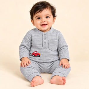 Baby wearing a light grey textured jacquard knit winter shirt and pajama set with red car embroidery