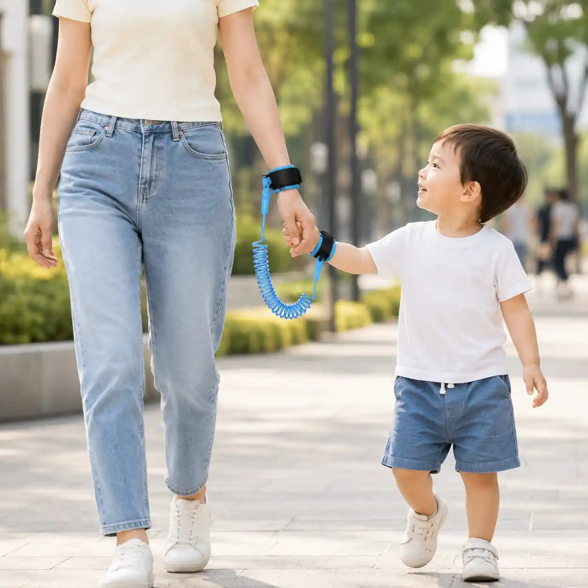 Parent and child using blue anti-lost wrist link while walking outdoors