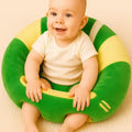 Baby sitting comfortably in a green and yellow plush support seat