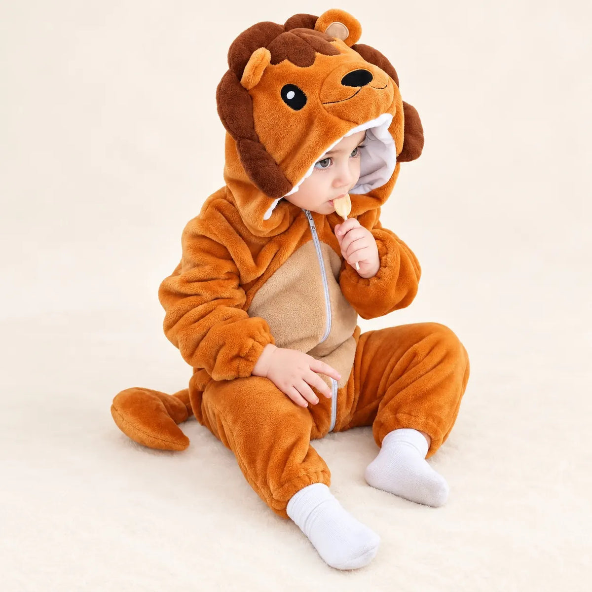 Child sitting in orange brown Lion Soft Fleece Costume Jumpsuit with animal hood, front zipper and plush lion tail