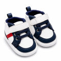 White and navy blue casual baby shoes with red side accent angled view