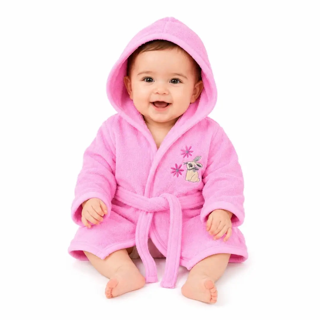 Baby wearing pink hooded bathrobe with bunny embroidery