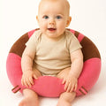 Baby sitting in a pink plush support seat with brown accents