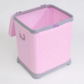 Pink plastic laundry basket with lid, woven texture and side handles