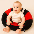 Baby sitting in a red and black plush support seat