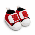 Side-angle view of red and white Velcro prewalker shoes for babies