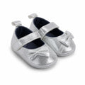 Side-angle view of silver baby girl shoes with bow and adjustable strap