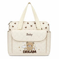 Cream baby diaper bag with teddy design, changing sheet and shoulder strap