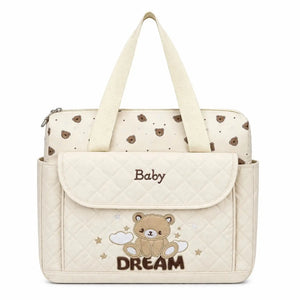 Cream baby diaper bag with teddy design, changing sheet and shoulder strap